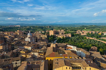 Aerial and top view scenery of old ancient Tuscany region town and medieval brick buildings with green range mountain landscape background in Siena, Italy  