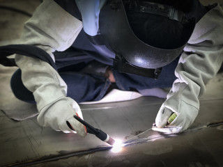 Worker welding stainless plate using tig welder