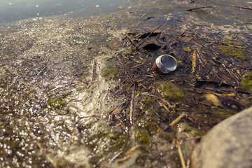 Old can floating in the river in a nature reserve
