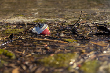 Old can floating in the river in a nature reserve