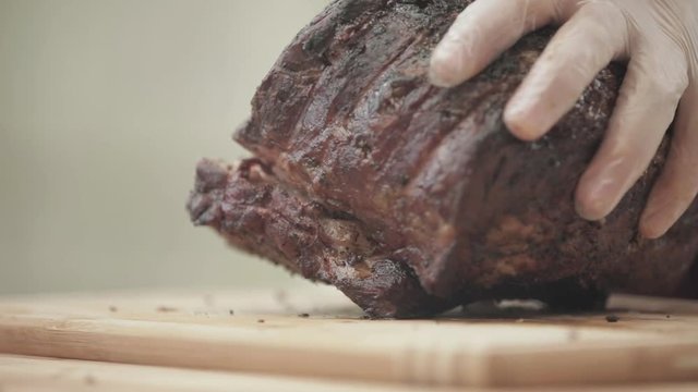 Man slices up a grilled prime rib outside in backyard