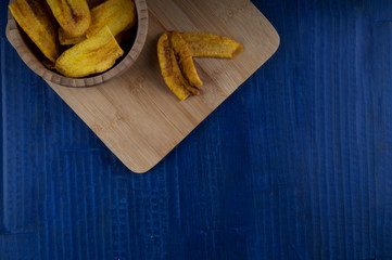 fried bananas ina bowls with blue rustic background