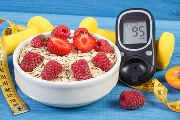 Glucometer, oat flakes with fruits, dumbbells and centimeter, concept of diabetes and healthy lifestyle