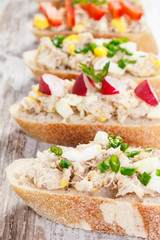 Closeup of crusty baguette with mackerel or tuna fish paste, healthy nutrition