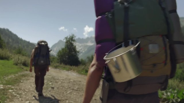 The bowler hanging from the traveler's backpack