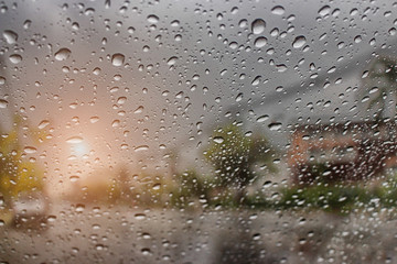 Raindrop outside the car in raining day at street with sunlight. Good view from driver seat during travel.