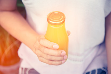 Obraz na płótnie Canvas Juice in bottle in woman hand