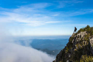 Man on rock , mist and mountains view