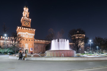 Fototapeta premium Milan, square Castello, Italy. Public pedestrian path in front of the castello Sforzesco (Sforza Castle) main entrance, 14 - 15th century, in the evening. The sforza castle is a symbol of Milan