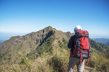 Hiker with backpack, enjoying view of mountain 