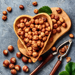 Hazelnuts with nutcracker on gray background. Top view of nuts.