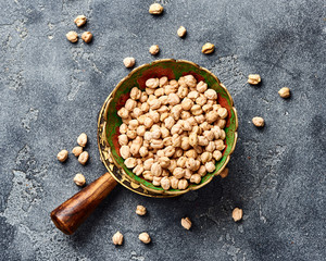 Dried chickpeas in bowl on a gray background. Top view.