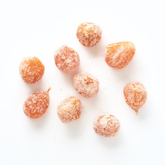 Dried sweet kumquat under powdered sugar isolated on white background. Top view.