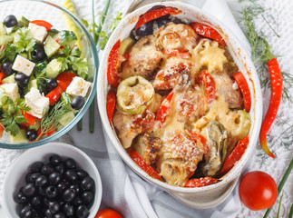 Traditional tasty rustic stew of chicken and vegetables  with Greek salad and black olives
