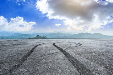 Empty asphalt square car tire brakes and mountain scenery