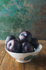 Red plums on rustic background