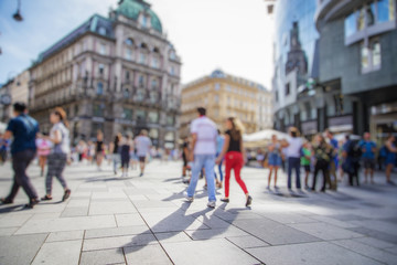 Crowd of anonymous people walking on busy city street
