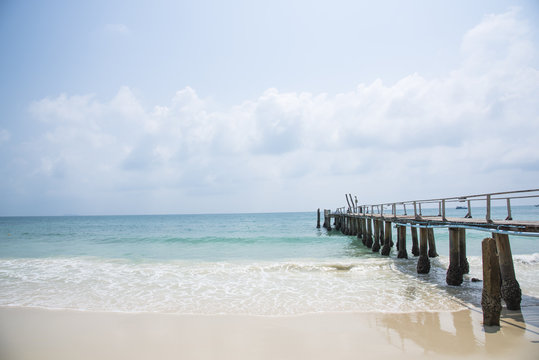 Wood bridge on the blue sea and sand