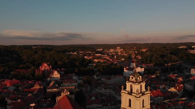 Aerial. Drone fly away of the campanile of St. John's church at the sunset in Vilnius, Lithuania, Europe. (sventu jonu varpine) Old town in the background.