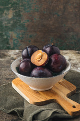 Red plums on rustic background