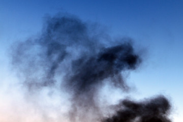 dark smoke on the light sky background.