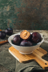 Red plums on rustic background