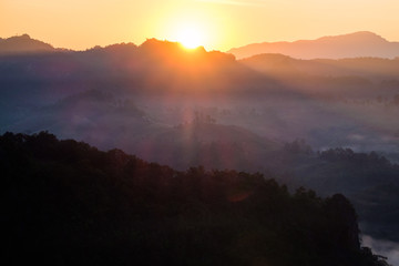 Fototapeta premium Sunrise shine on mountain in fog valley