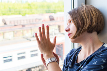 sad woman sitting by the window