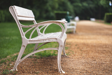 a white bench stands in the park.