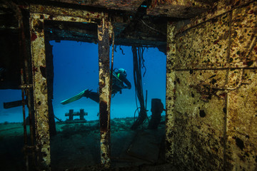 A scuba diver swims past the shipwreck