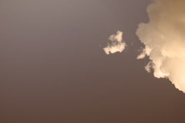 Due nuvole bianche su sfondo color seppia. Copy space sulla sinistra della foto