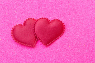 Red heart on pink sand