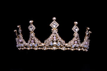 golden crown with pearls and beads isolated on black © vitaly tiagunov