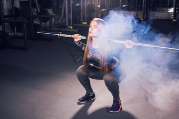 sport, fitness, training and happiness concept - sporty woman with barbell in gym