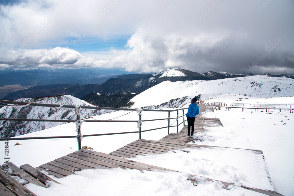 Wall mural tourist woman standing and enjoy view of beautiful snow mountains name 