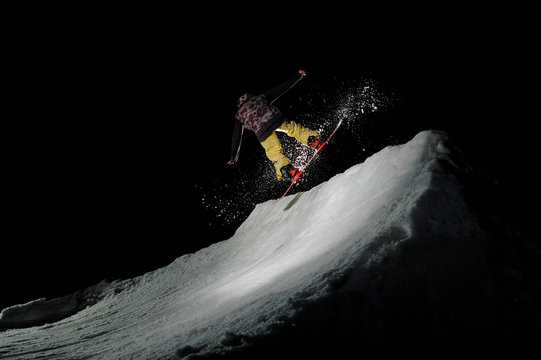 man jumping on a snowboard against the dark sky