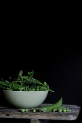Green beans on wooden table in dark background