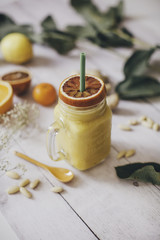 Orange smoothie in white wooden background