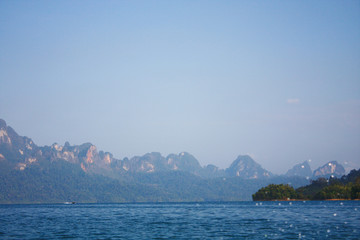 Landscape of Dam with Mountain and river near forest hills in Blue sky at Ratchaprapha Dam at Khao Sok National Park, Surat Thani Province, Thailand.