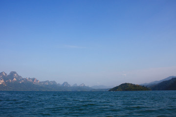 Landscape of Dam with Mountain and river near forest hills in Blue sky at Ratchaprapha Dam at Khao Sok National Park, Surat Thani Province, Thailand.