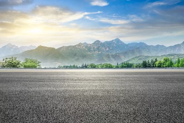 Photo sur Aluminium Gris Autoroute asphaltée vide et paysage naturel de montagne verte au coucher du soleil