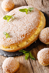 Delicious tropezienne tarte brioche cake with tender cream decorated with pearl sugar and mint closeup. vertical
