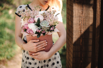 Woman dressed in polka dot dress holding a big flower box