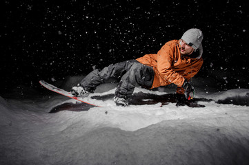 Man riding on the snowboard in the mountain resort in the night