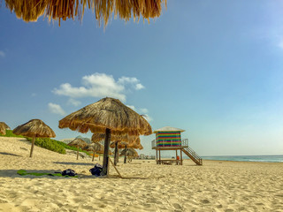 Beach in Cancun, Mexico with straw umbrellas