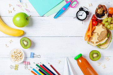 Back to school concept. Healthy lunch box and colorful stationery on white wooden table top view.