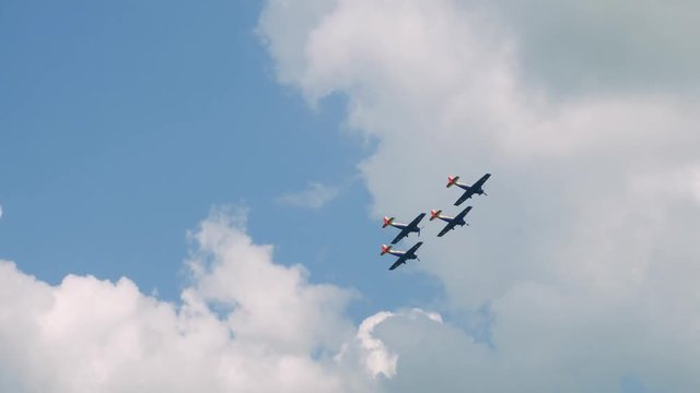 Old small planes flying in formation exercise.
