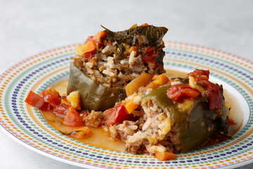 Peppers stuffed with meat and bulgur in round mosaic plate, close up view