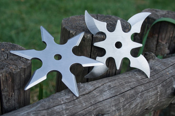Shuriken (throwing star), traditional japanese ninja cold weapon stuck in wooden background