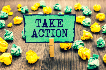 Fototapeta premium Text sign showing Take Action. Conceptual photo advices someone to do something or reaction right now Clothespin holding green note paper crumpled papers several tries mistakes.